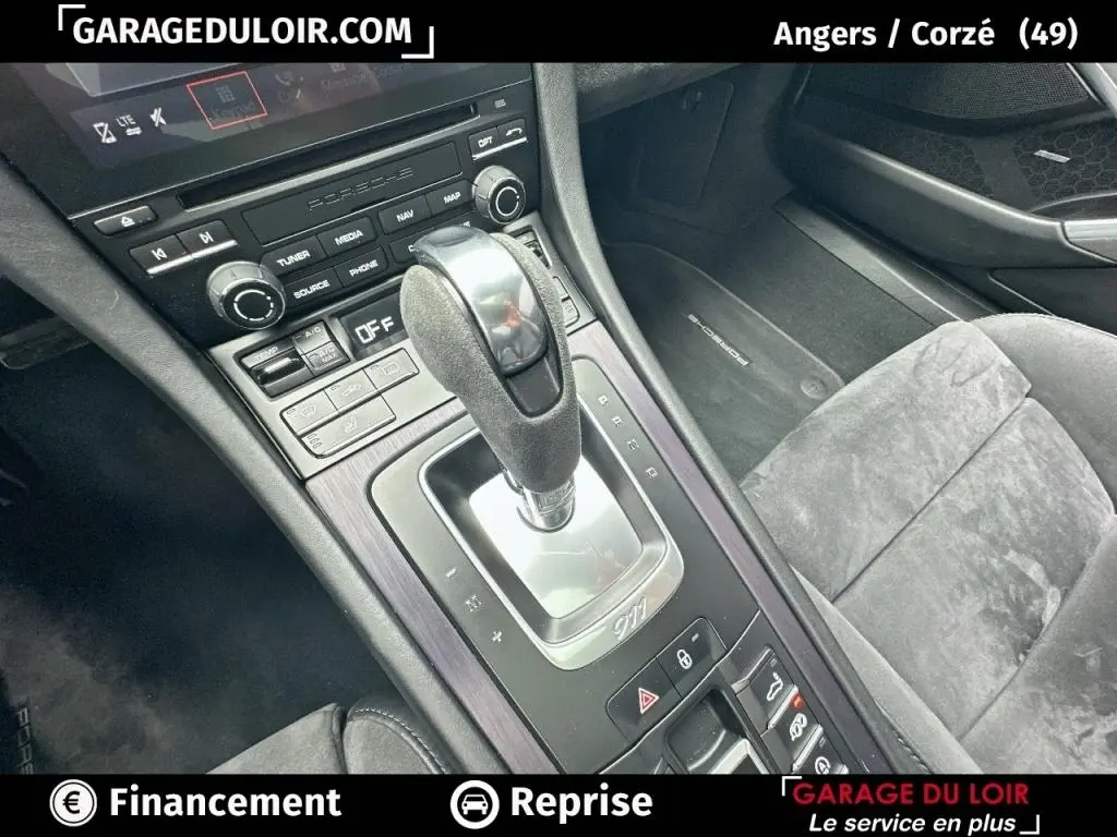 Vue rapprochée de la console centrale et du levier de vitesse gris foncé dans l'habitacle noir de la Porsche 911 Carrera GTS Coupé.