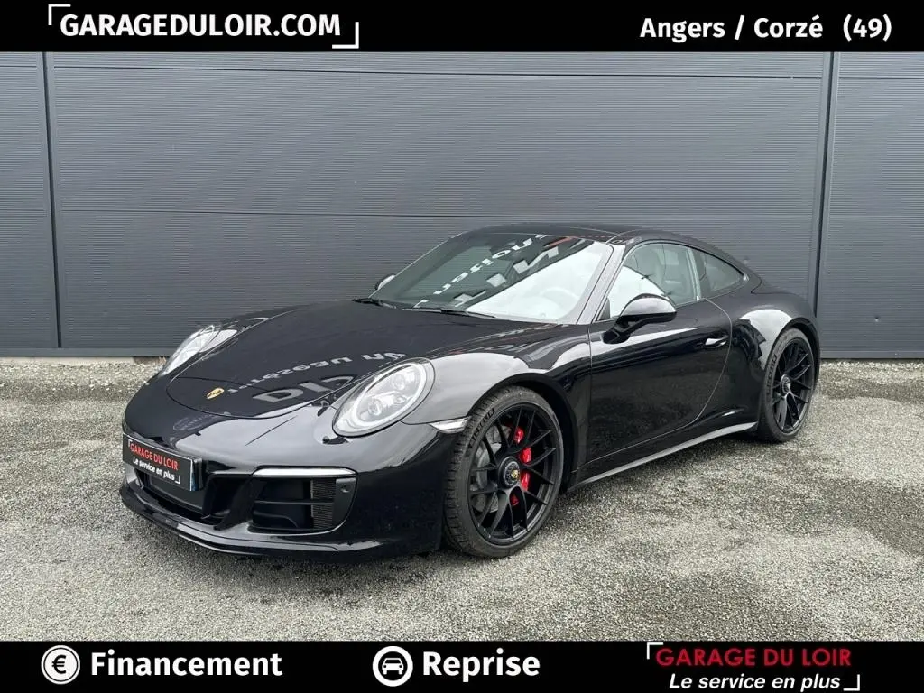 Vue 3/4 avant droite d'une Porsche 911 Carrera GTS Coupé noire avec jantes noires et étriers rouges.