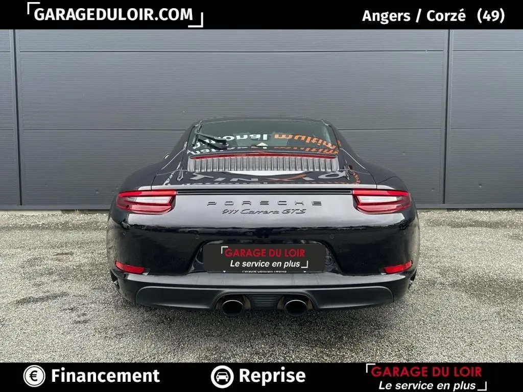 Vue arrière d'une Porsche 911 Carrera GTS Coupé noire, avec double sortie d'échappement centrale et feux arrière LED.