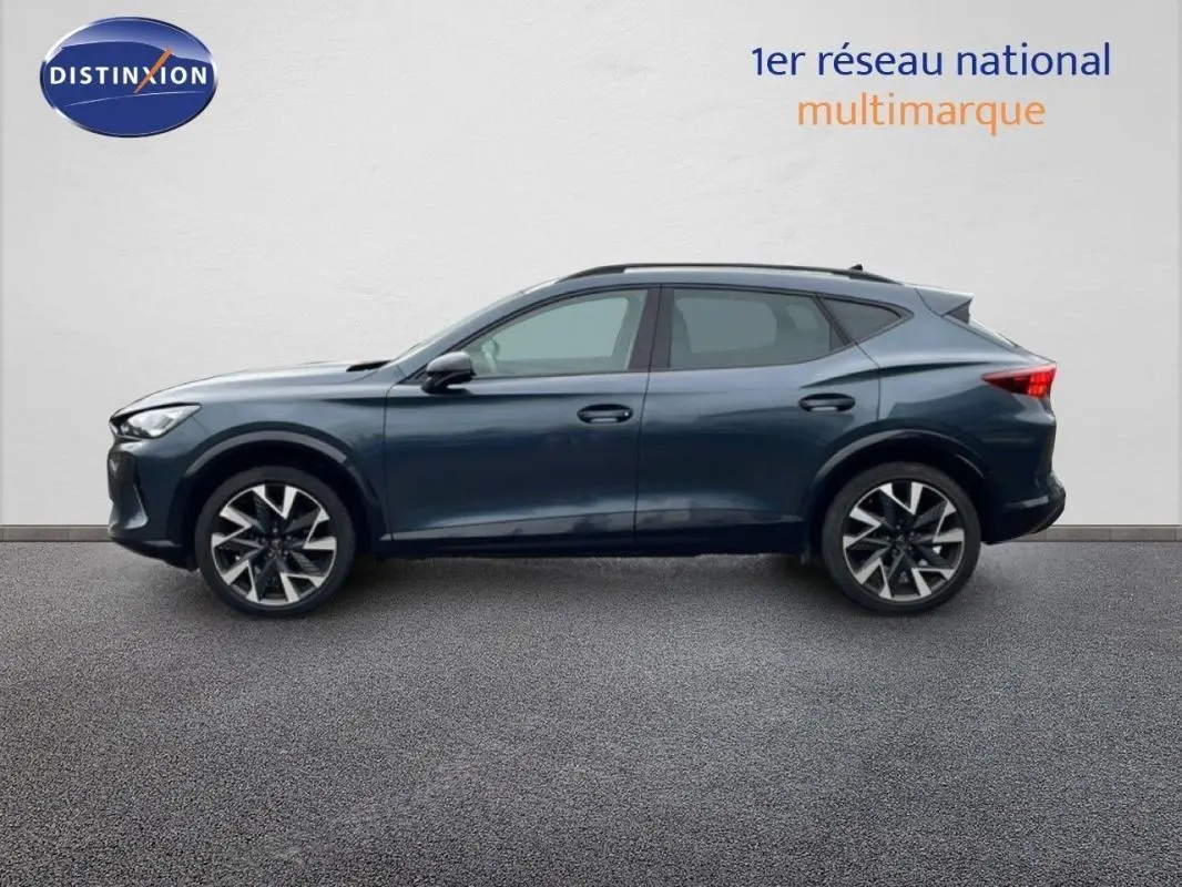 Vue latérale droite d'un CUPRA Formentor gris 2025 avec jantes aluminium et barres de toit visibles.