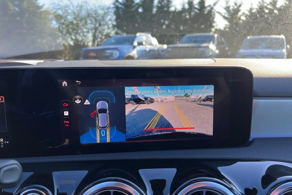 Vue intérieure du tableau de bord d'une Mercedes Classe A 200D Exclusive Design avec écran affichant la caméra de recul.