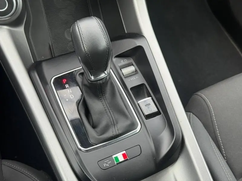 Gros plan sur la console centrale de l'Alfa Romeo Tonale 1.5 Hybrid, levier de vitesse cuir et bouton frein électrique.