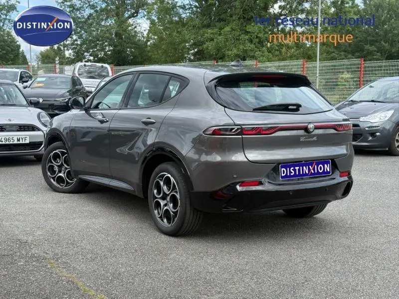 Vue 3/4 arrière droite de l'Alfa Romeo Tonale 1.5 Hybrid gris Vesuvio métallisé avec feux arrière LED et jantes alu distinctives.