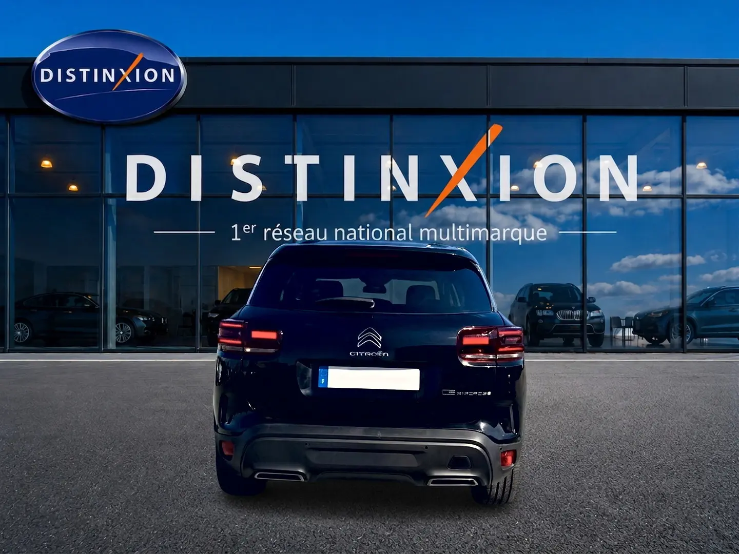 Vue arrière d'un Citroën C5 Aircross noir 2024, avec feux LED et logo Citroën bien visibles, devant une vitrine Distinxion.