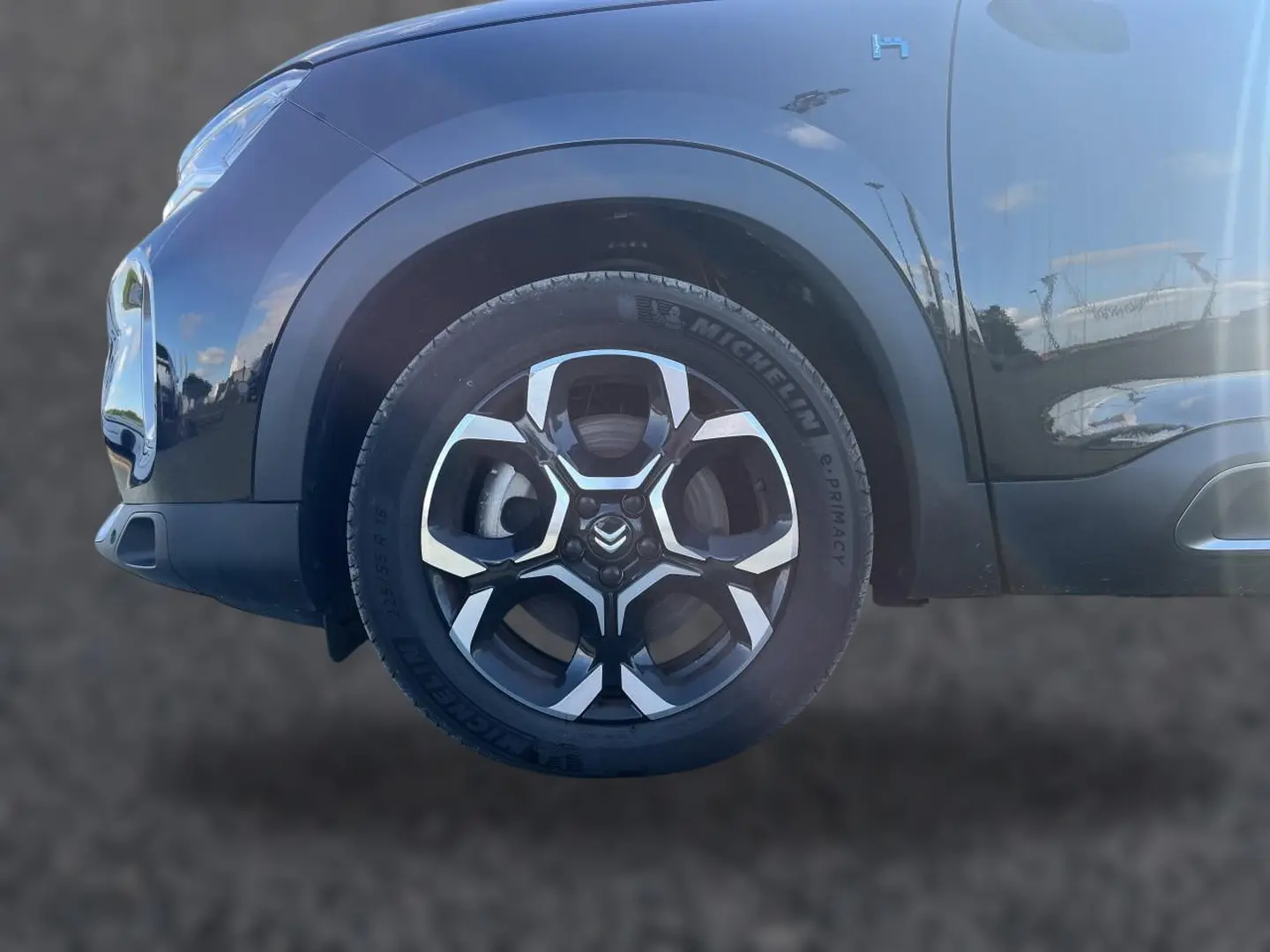 Gros plan sur la roue avant gauche noire du Citroën C5 Aircross 2024 avec jante alu et logo Citroën visible.