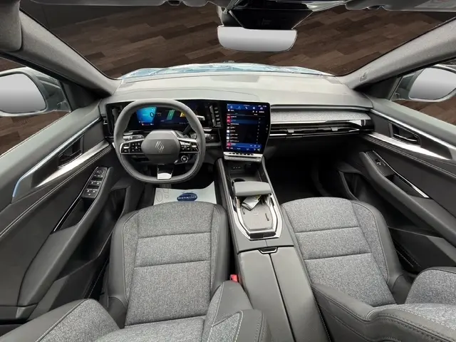 Vue intérieure avant du Renault Austral bleu 2026, tableau de bord moderne avec écran tactile vertical et volant multifonctions.