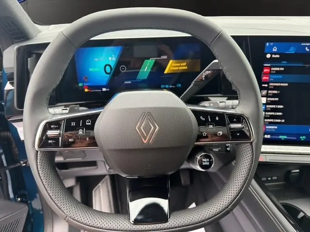 Vue centrée sur le volant cuir du Renault Austral bleu 2026 avec affichage numérique multifonctions et écran tactile latéral.