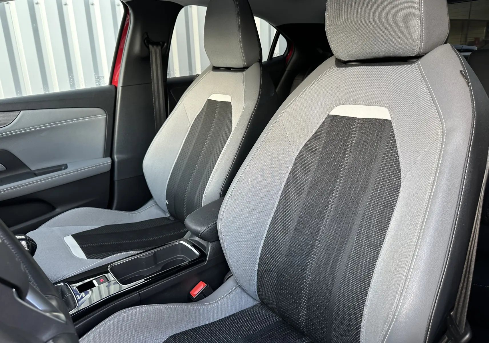 Vue intérieure des sièges avant gris et noir de l'Opel Mokka Rouge Kardinal, mettant en valeur les finitions modernes et le détail des textures.