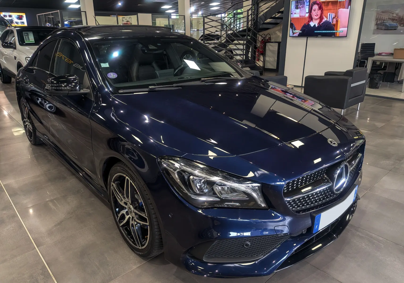Mercedes Classe CLA 200 Fascination bleu Cavansite en 3/4 avant droit, avec jantes AMG et calandre étoilée.