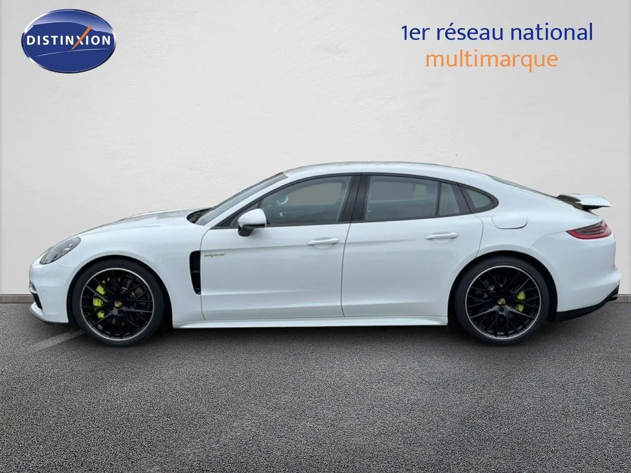 Profil côté gauche d'une Porsche Panamera 4 E-Hybrid blanche avec jantes sport noires et étriers verts.