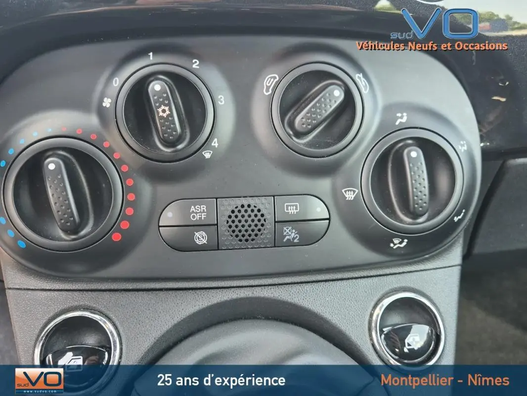 Gros plan sur les commandes de climatisation de la FIAT 500C noire 2024, avec boutons rotatifs et options visibles.