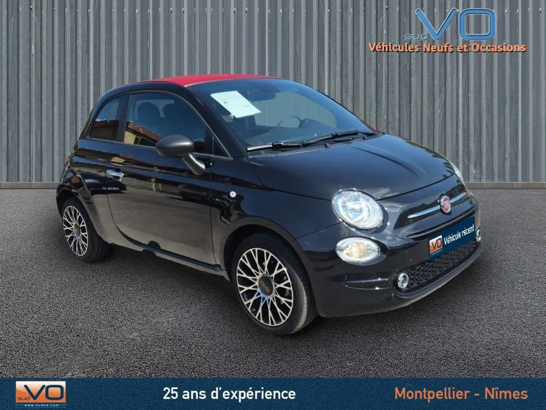 Vue 3/4 avant gauche d'une FIAT 500C noire 2024 avec toit rouge et jantes alliage distinctives.