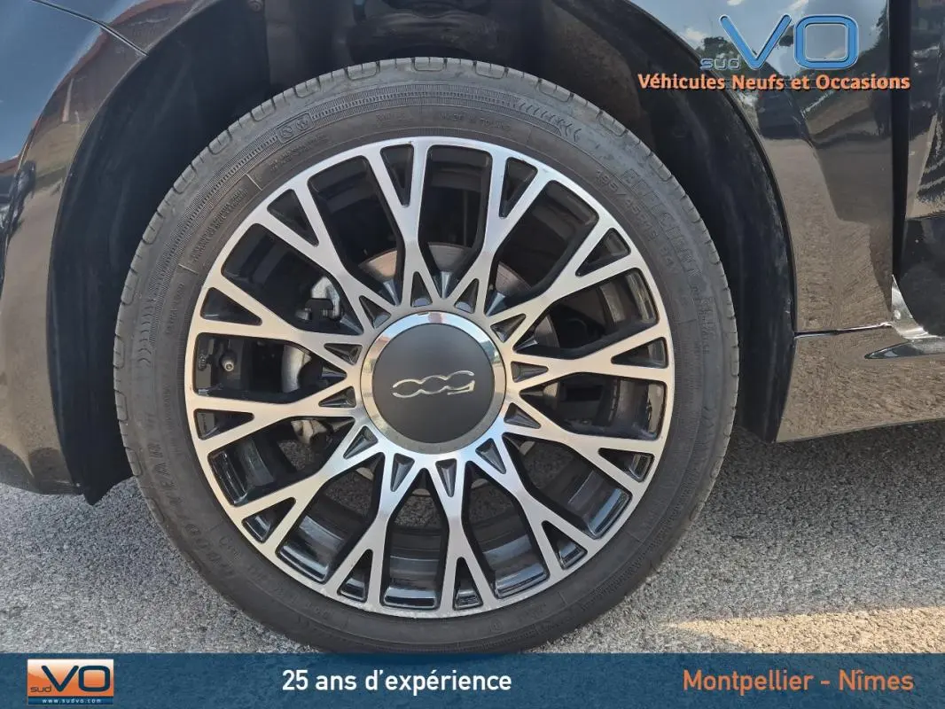 Gros plan sur la roue avant gauche noire avec jante multibranches du FIAT 500C 1.0 hybride 2024.