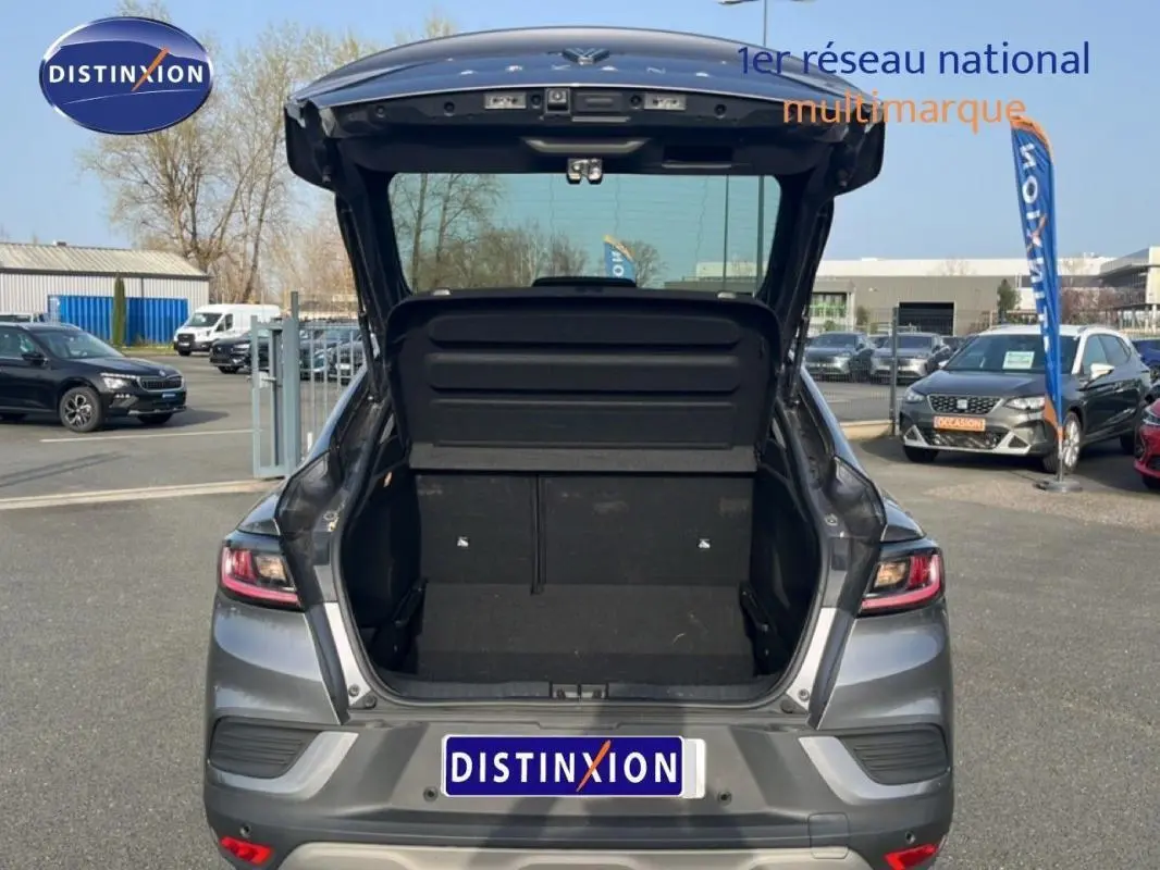 Vue arrière d’un Renault Arkana gris 2025 avec coffre ouvert et intérieur de coffre visible en extérieur.
