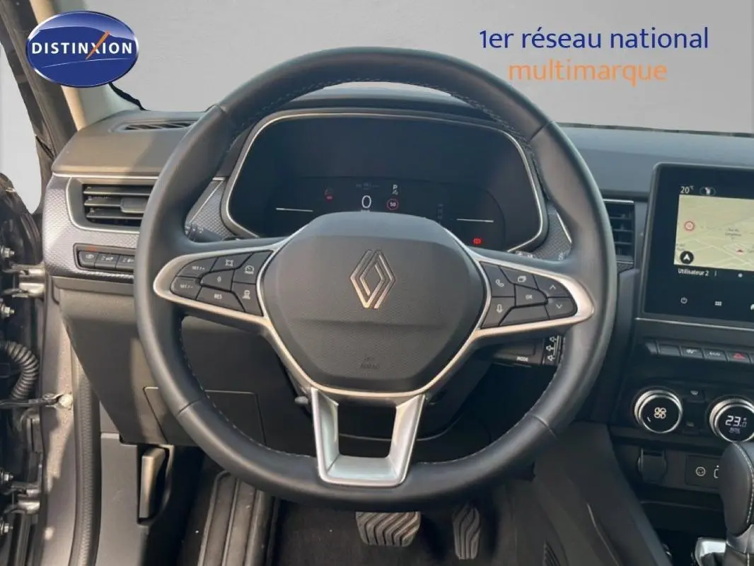 Vue intérieure centrée sur le volant cuir noir et le tableau de bord avec écran tactile du Renault Arkana gris 2025.
