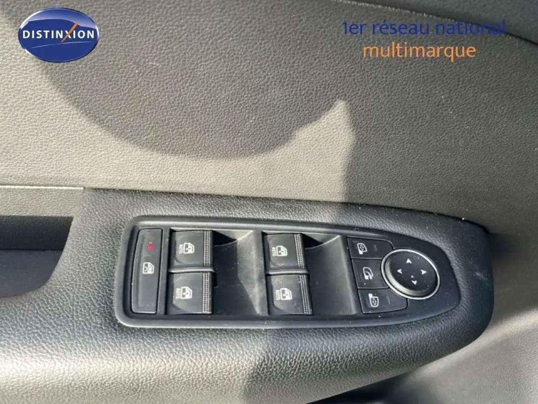 Gros plan sur les commandes des vitres électriques et rétroviseurs du côté gauche d’un Renault Arkana gris 2025.