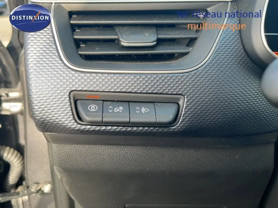 Détail intérieur montrant les commandes d’éclairage et de réglage du tableau de bord du Renault Arkana gris 2025.