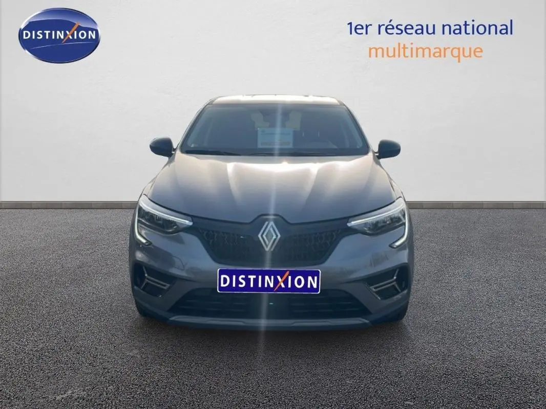 Vue frontale d'un Renault Arkana gris 2025 avec calandre noire et feux LED allumés sur fond neutre.