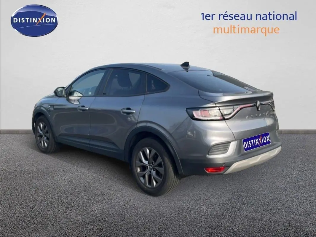 Vue 3/4 arrière droite d'un Renault Arkana gris 2025 avec jantes aluminium et feux LED reliés par un bandeau lumineux.