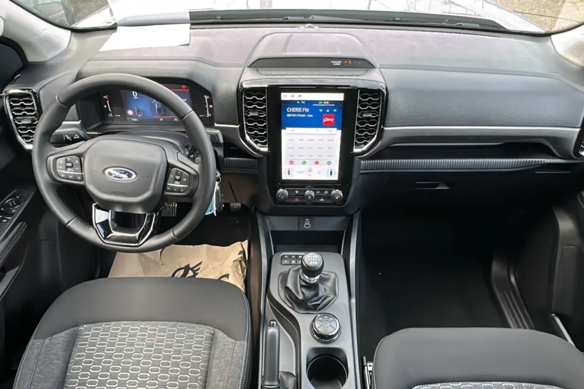 Vue intérieure du tableau de bord et console centrale du Ford Ranger 2026 avec volant multifonctions et écran tactile vertical.
