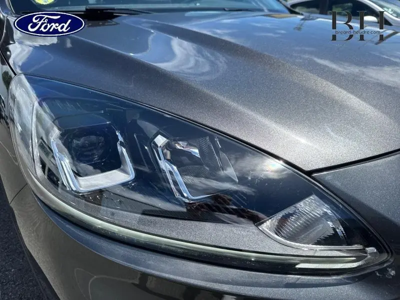 Gros plan sur le phare avant gauche du Ford Kuga gris Magnetic Métallisé, soulignant ses détails LED modernes.