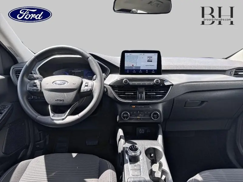 Vue intérieure avant du Ford Kuga 2022, tableau de bord et volant cuir multifonction en gris et noir.