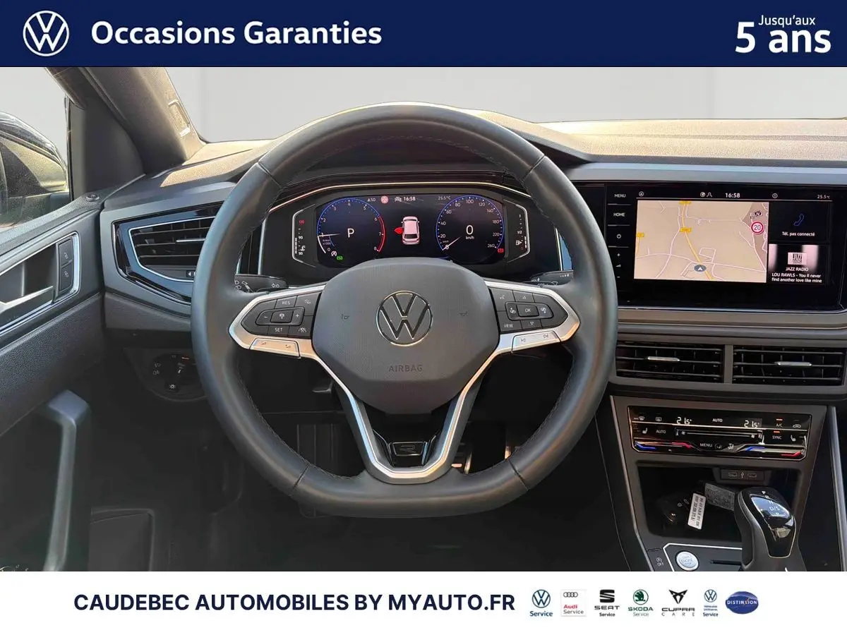 Vue intérieure centrée sur le volant cuir multifonctions et le tableau de bord digital de la Volkswagen Polo noire.