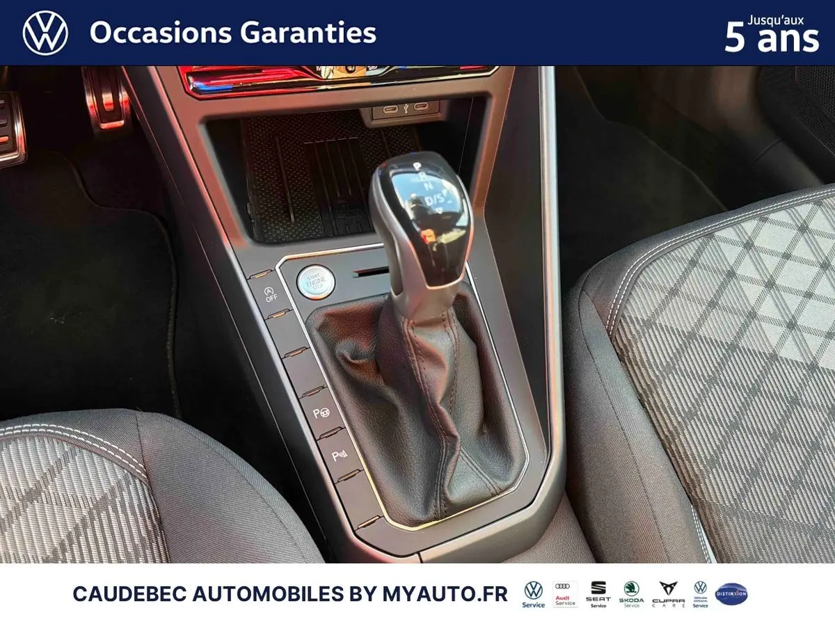Gros plan sur le levier de vitesse automatique DSG7 en cuir dans l’habitacle de la Volkswagen Polo noire intense nacrée.