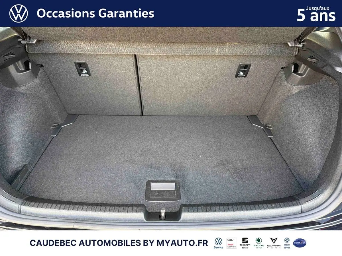 Coffre ouvert d'une Volkswagen Polo noire intense nacrée, montrant l'espace de chargement intérieur vide.