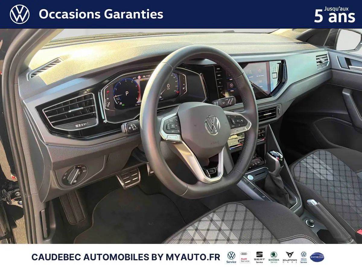 Vue intérieure avant gauche du Volkswagen Polo 2026 noir intense nacré, volant cuir et tableau de bord digital.