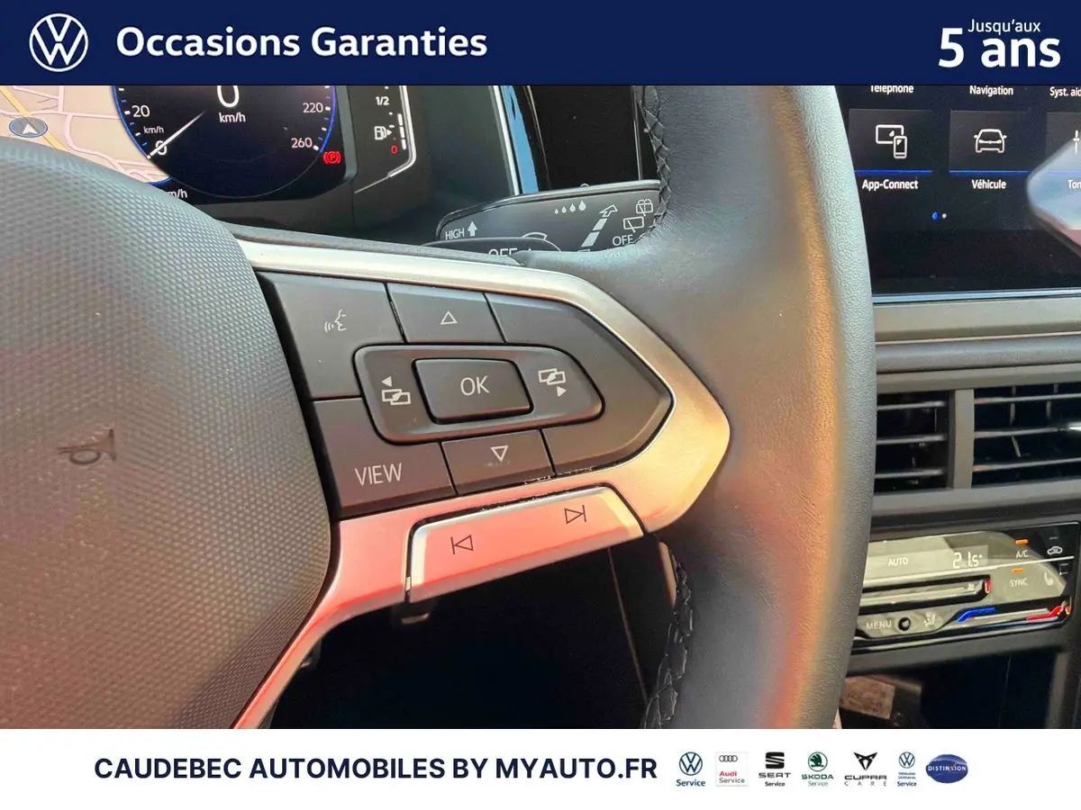 Gros plan sur le volant multifonctions en cuir et la partie droite du tableau de bord tactile de la Volkswagen Polo noire.