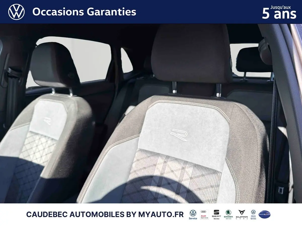 Gros plan sur les sièges avant gris clair et foncé avec logo R, intérieur d'une Volkswagen Polo noire.