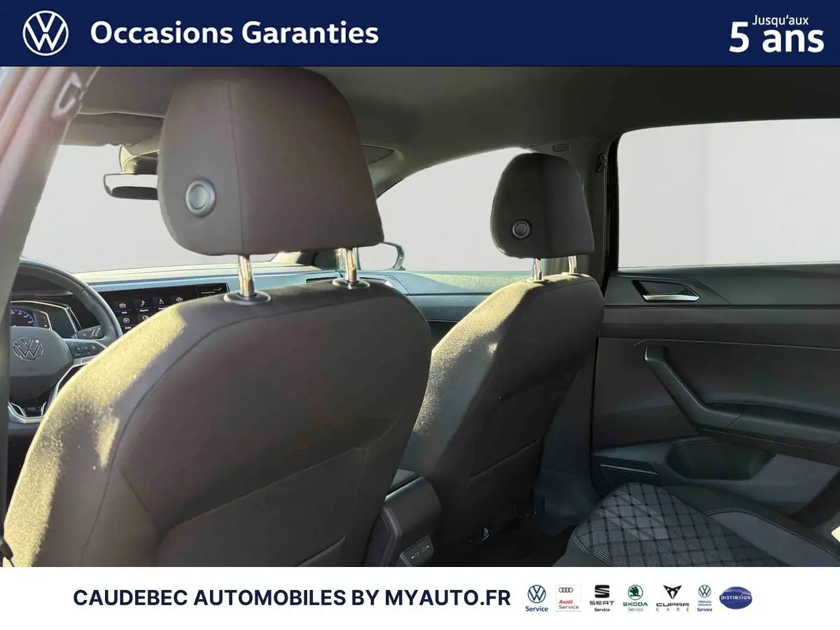 Vue intérieure arrière de la Volkswagen Polo 2026, sièges noirs et tableau de bord moderne visible côté droit.