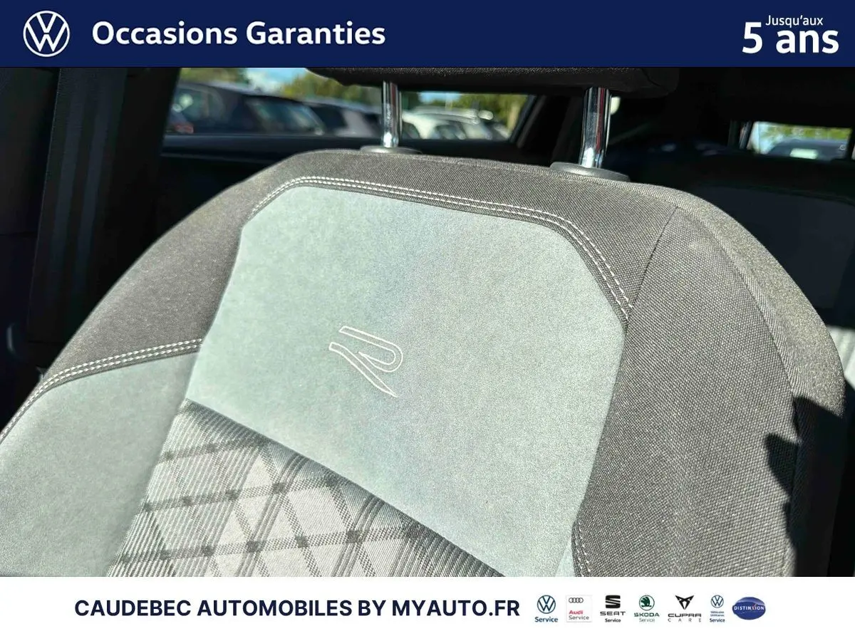 Gros plan sur l’appui-tête avant gris clair et foncé avec logo R brodé, intérieur d’une Volkswagen Polo noire.