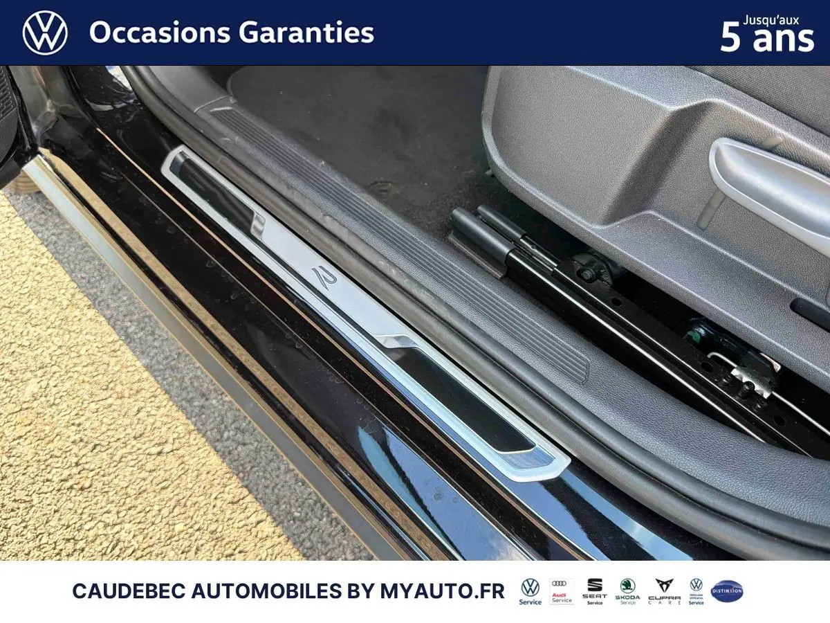 Détail du seuil de porte côté conducteur noir intense nacré sur Volkswagen Polo 2026 avec logo R-Line visible.