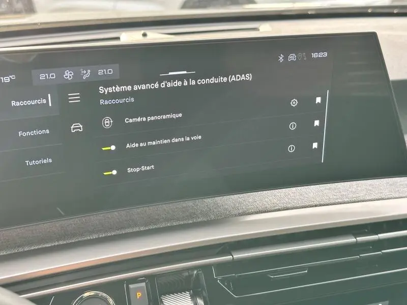 Écran tactile du système d'aide à la conduite dans l'habitacle du Peugeot 3008 gris titane 2025.