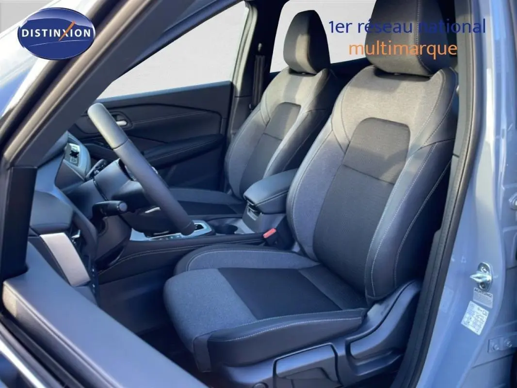 Vue intérieure côté conducteur du Nissan Qashqai gris 2025, mettant en valeur les sièges et le volant cuir.