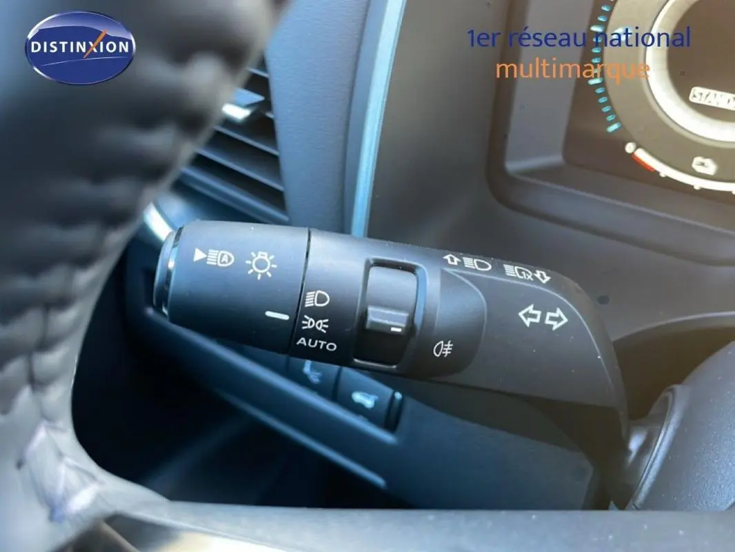 Gros plan sur la commande des feux et clignotants du Nissan Qashqai gris 2025, avec tableau de bord partiellement visible.