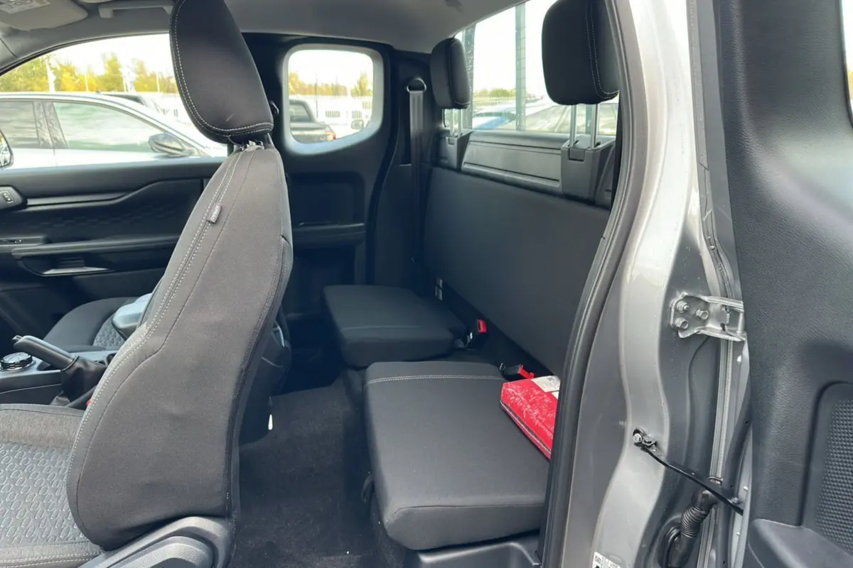 Vue intérieure côté droit du Ford Ranger gris iconic 2026, montrant la banquette arrière et siège avant en tissu noir.