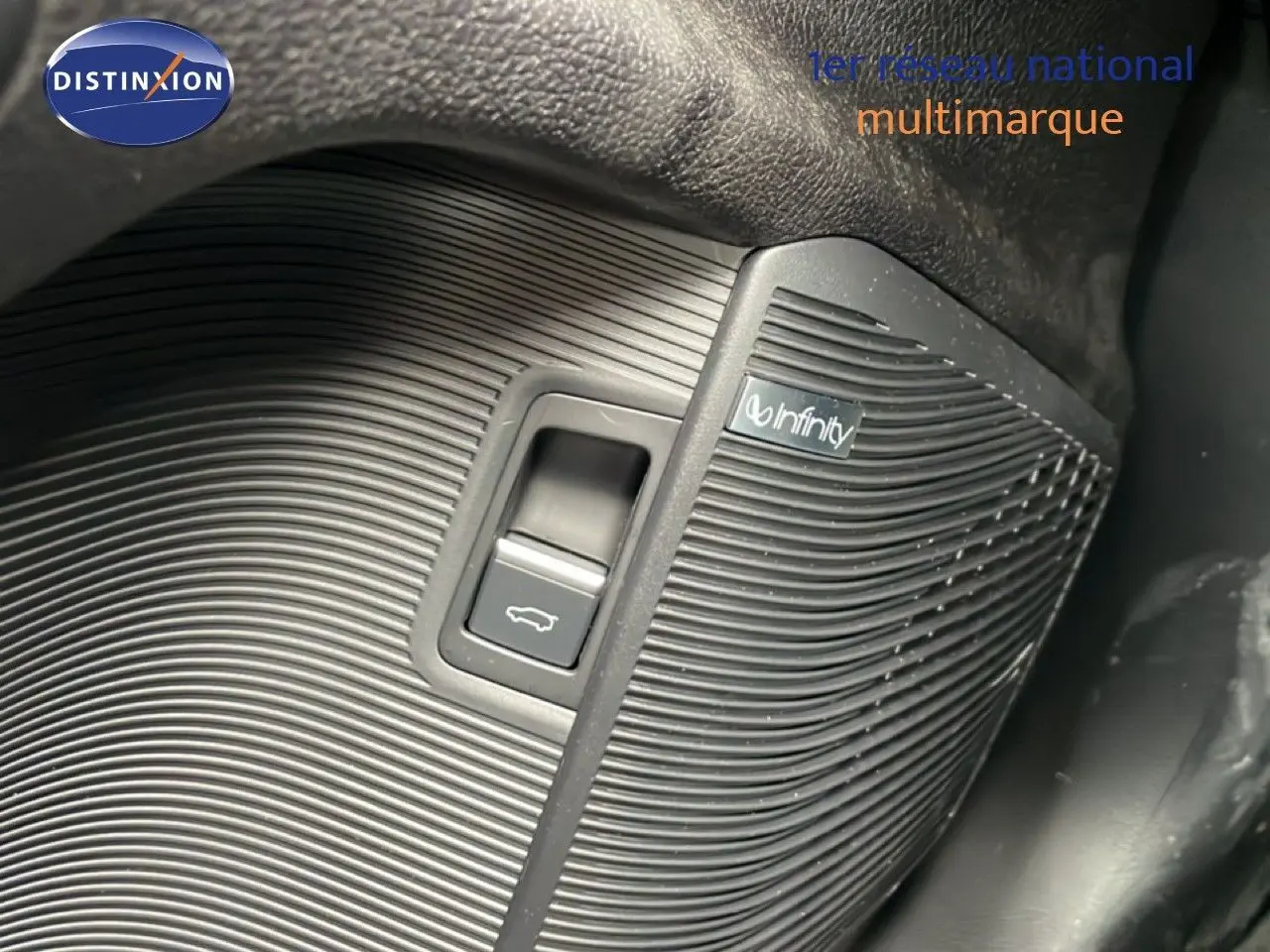 Détail du bouton d'ouverture de coffre avec haut-parleur Infinity sur le panneau intérieur d'une BYD SEAL U 2026.
