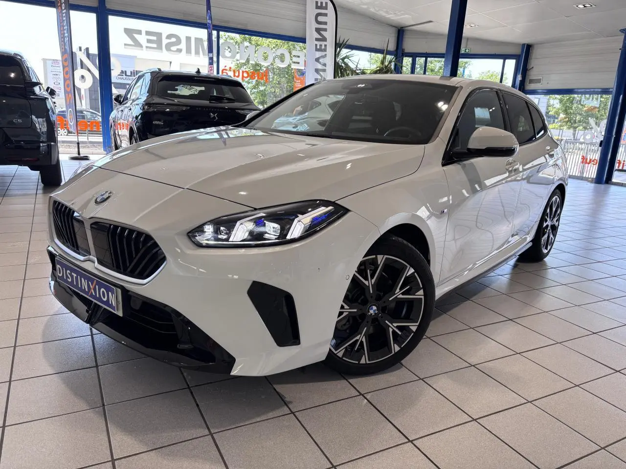 BMW Série 1 120d M Sport blanche vue en 3/4 avant droit, avec calandre noire et jantes alliage distinctives.
