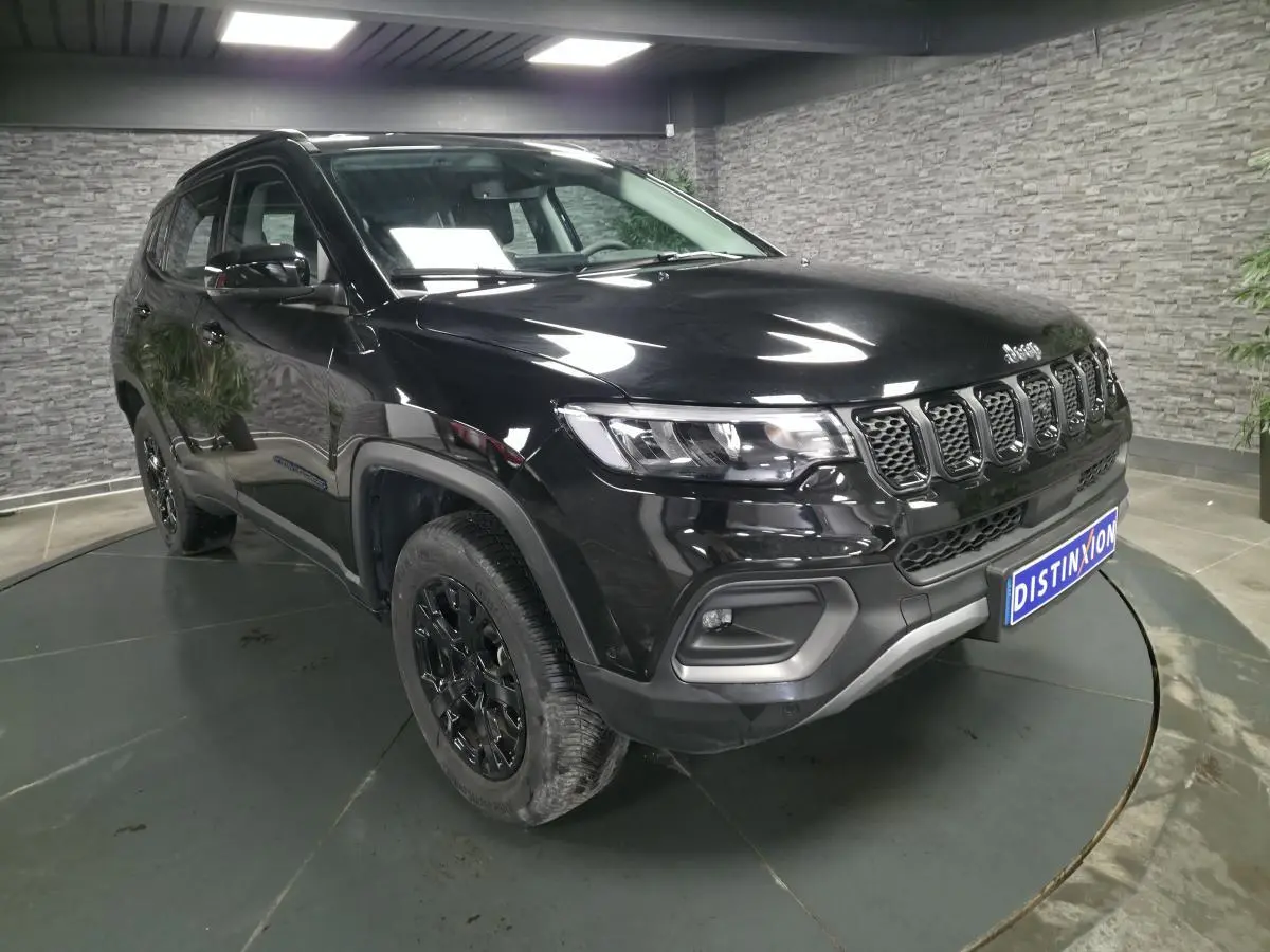 Jeep Compass noir en vue 3/4 avant droit, avec calandre distinctive et jantes alliage noires brillantes.