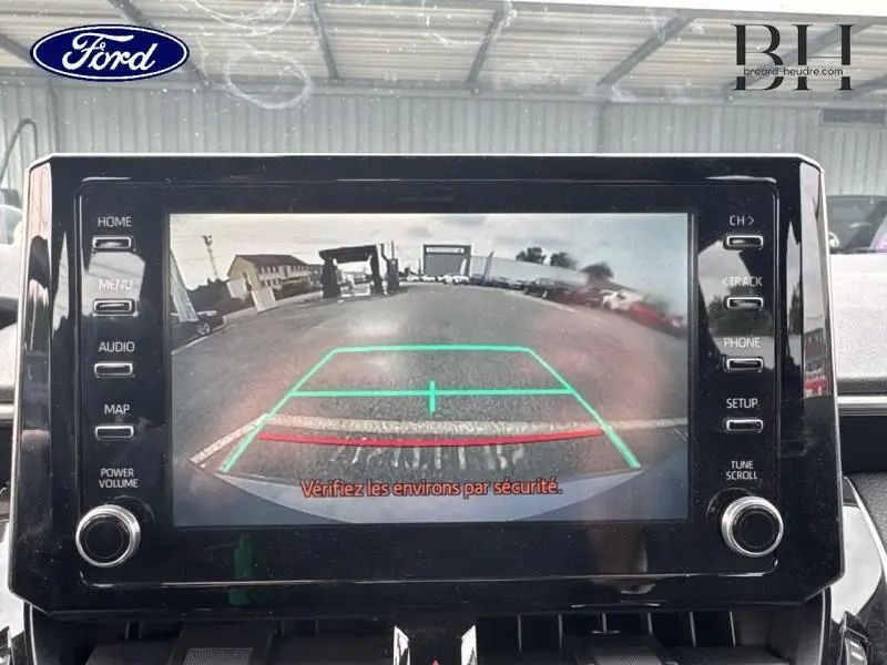 Écran de caméra de recul d’une Toyota Corolla gris Manhattan, affichant la vue arrière avec lignes de guidage colorées.