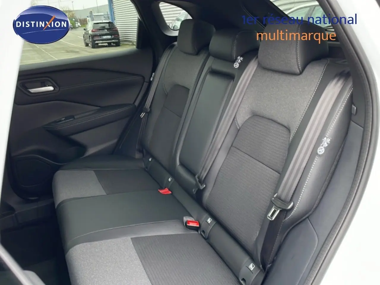 Vue intérieure sur la banquette arrière du Nissan Qashqai blanc nacré, avec sièges tissu et cuir noir.