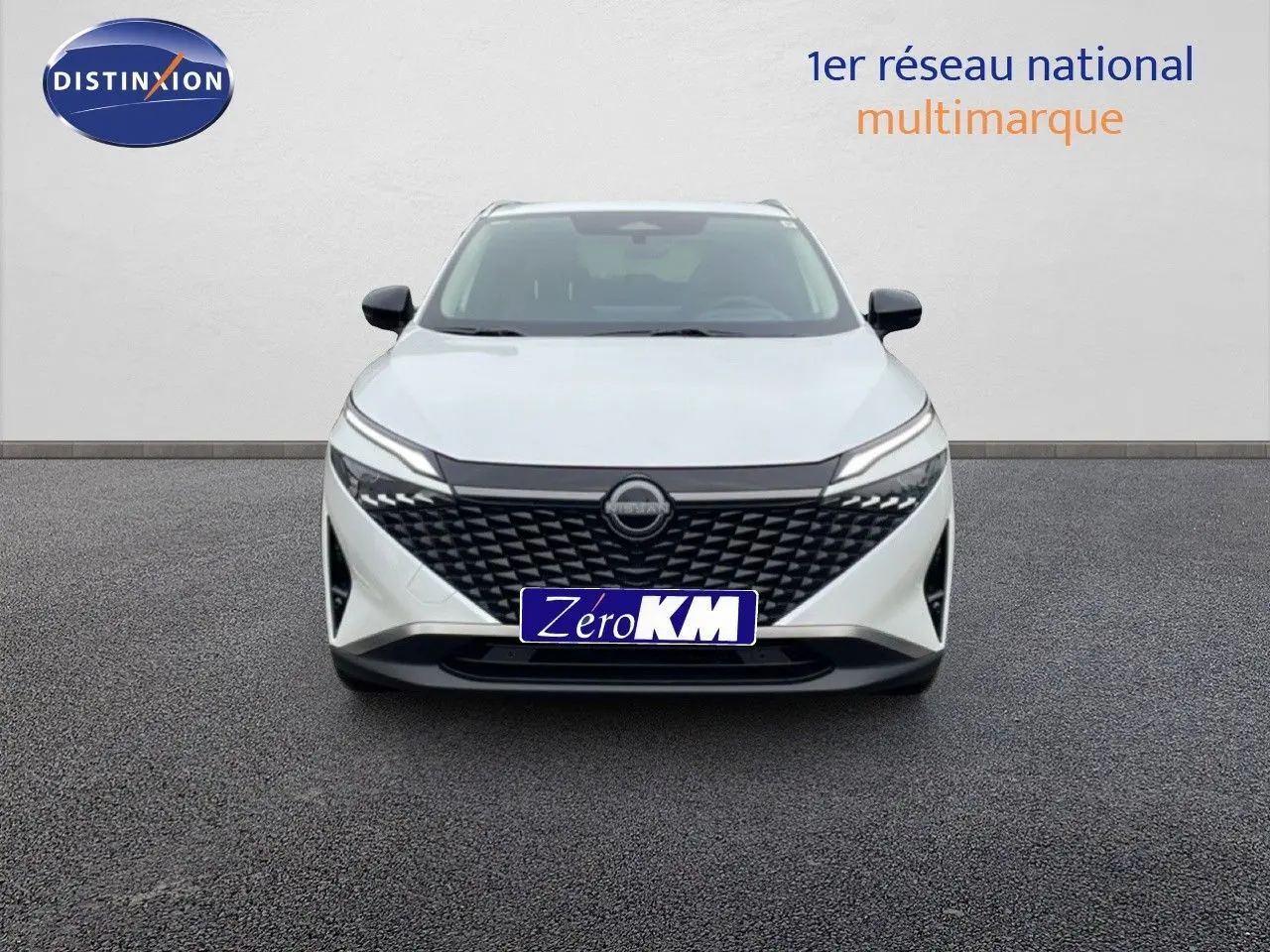 Vue frontale d'un Nissan Qashqai blanc nacré métal avec calandre noire texturée et phares LED fins.