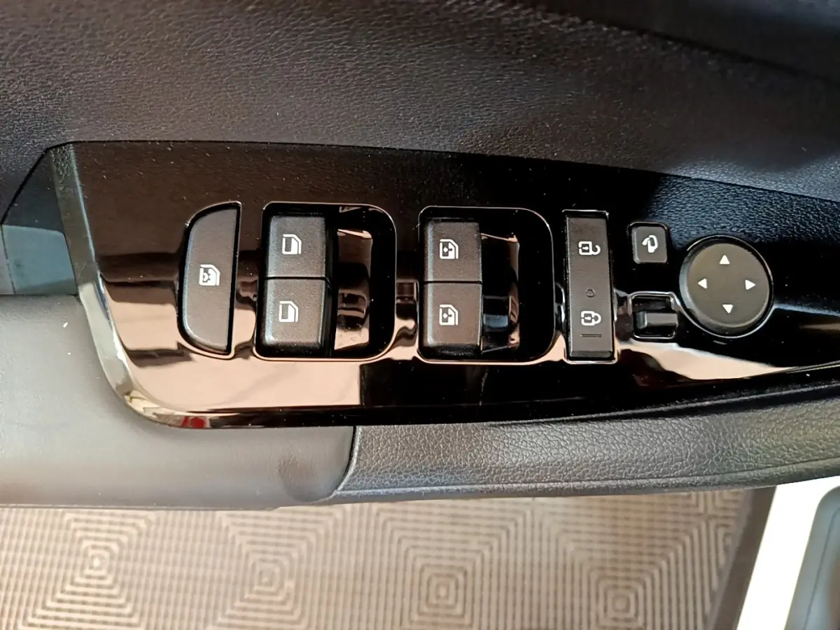 Gros plan sur les commandes de lève-vitres et rétroviseurs côté conducteur du KIA Sportage blanc 2022.