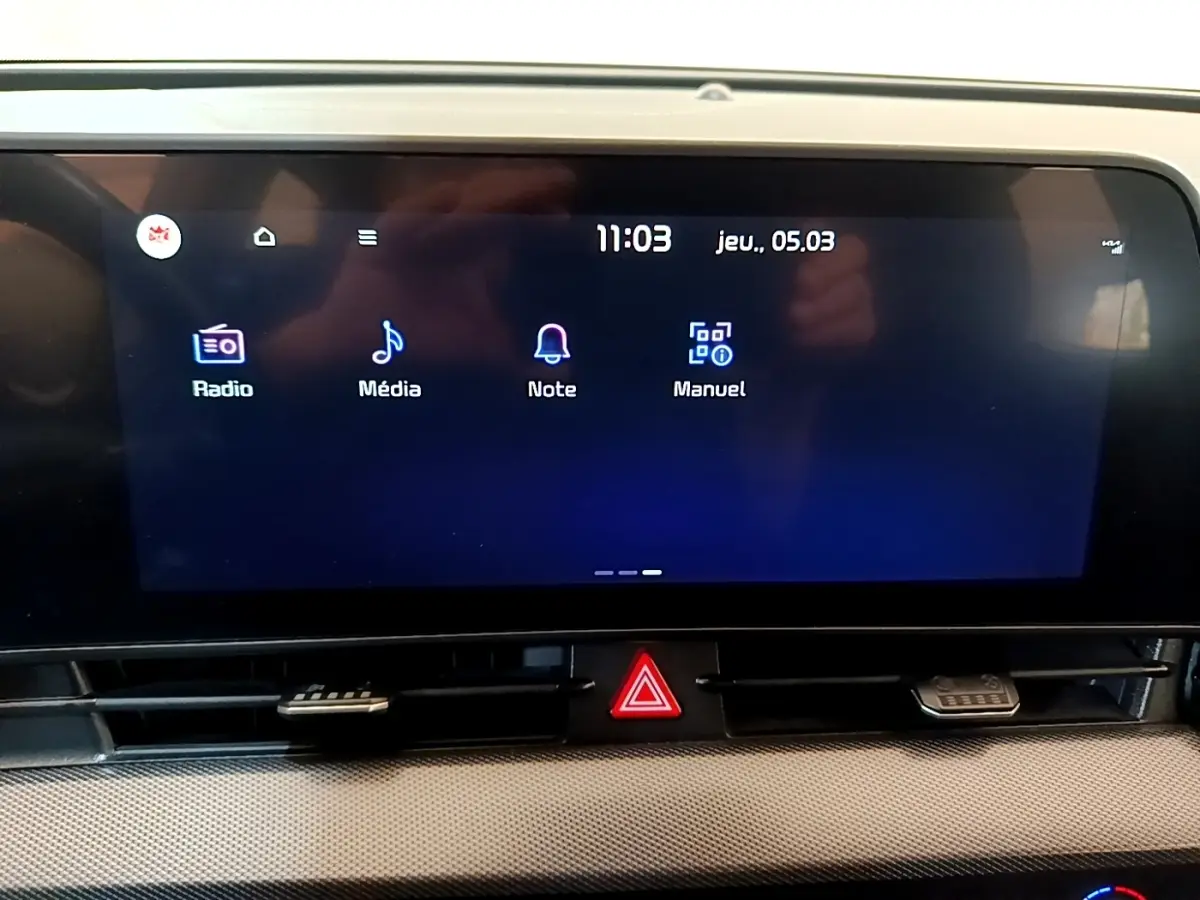 Écran tactile central du tableau de bord du Kia Sportage blanc, affichant les options Radio, Média, Note et Manuel.