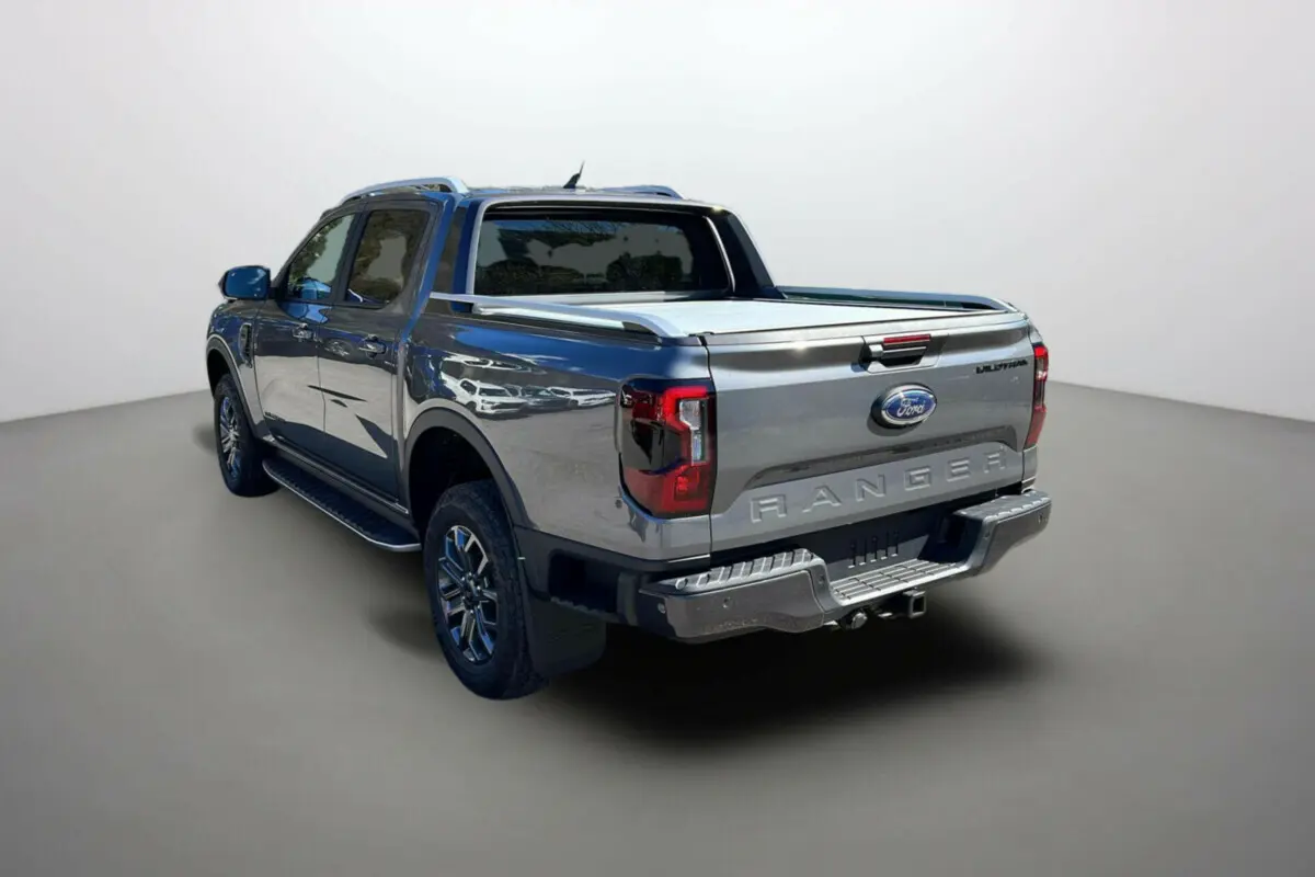 Ford Ranger 2.0 Wildtrak gris carbone vu en 3/4 arrière droit avec rideau coulissant et jantes alu 18 pouces.