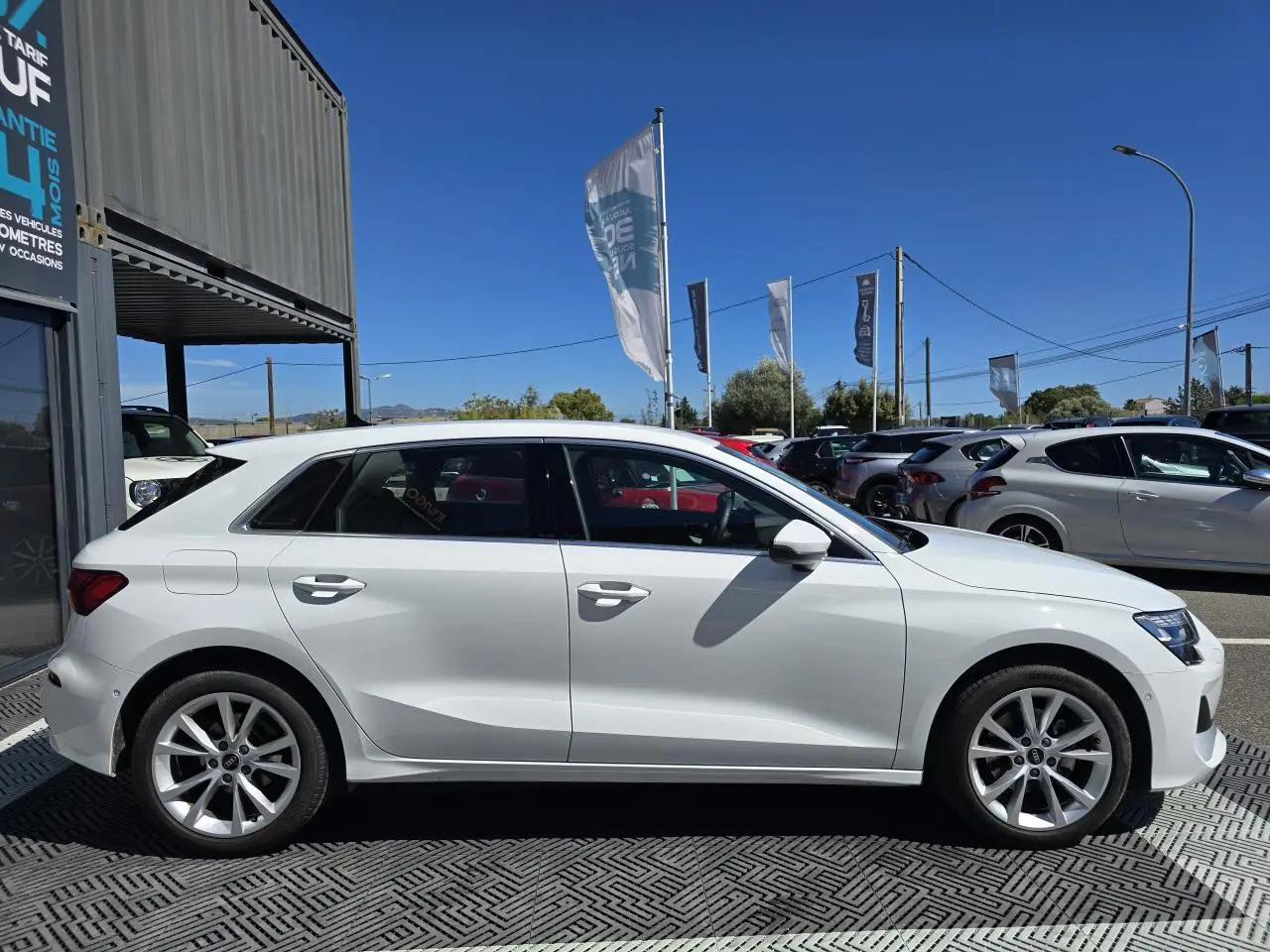 Profil latéral droit d'une Audi A3 Sportback 2024 en blanc Arkona avec jantes alliage 5 branches parallèles.