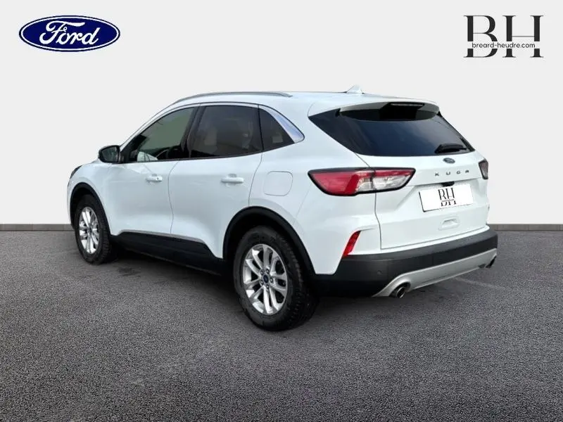 Vue 3/4 arrière droite du Ford Kuga blanc Glacier avec vitres arrière surteintées et jantes alu.